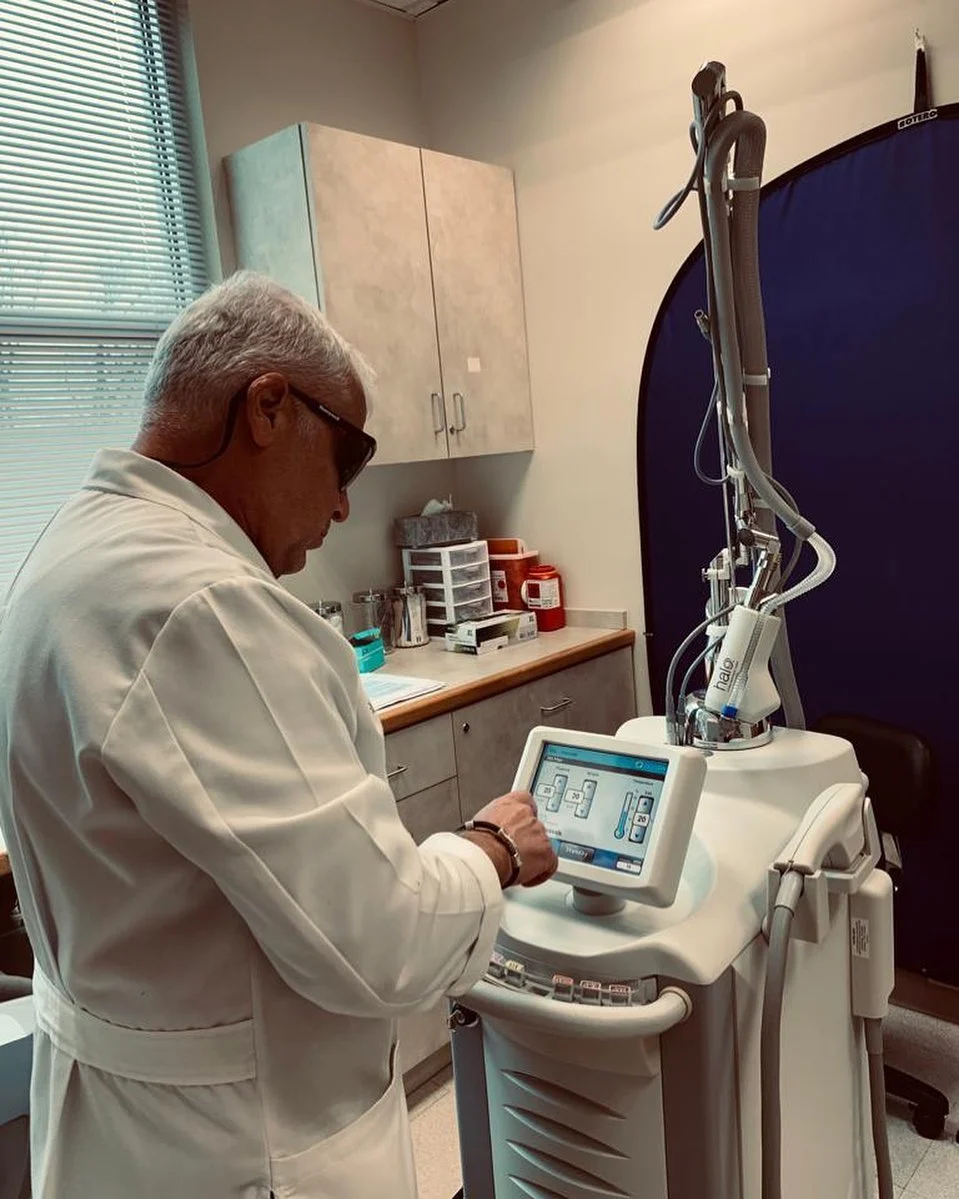 Dr. Boris Mordkovich operating broad-band light therapy equipment controls in a clinical treatment room